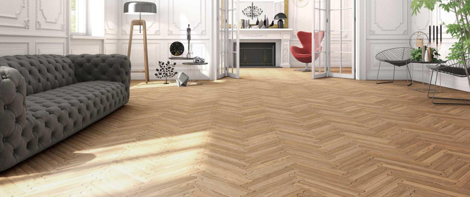 sala da pranzo con parquet listone giordano, divano grigio e pareti bianche